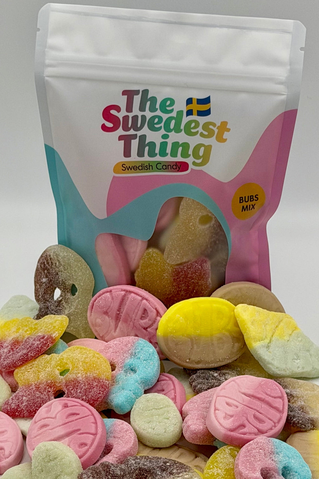 Colorful gummy candies in front of a 'The Swedest Thing' branded bag on a white background