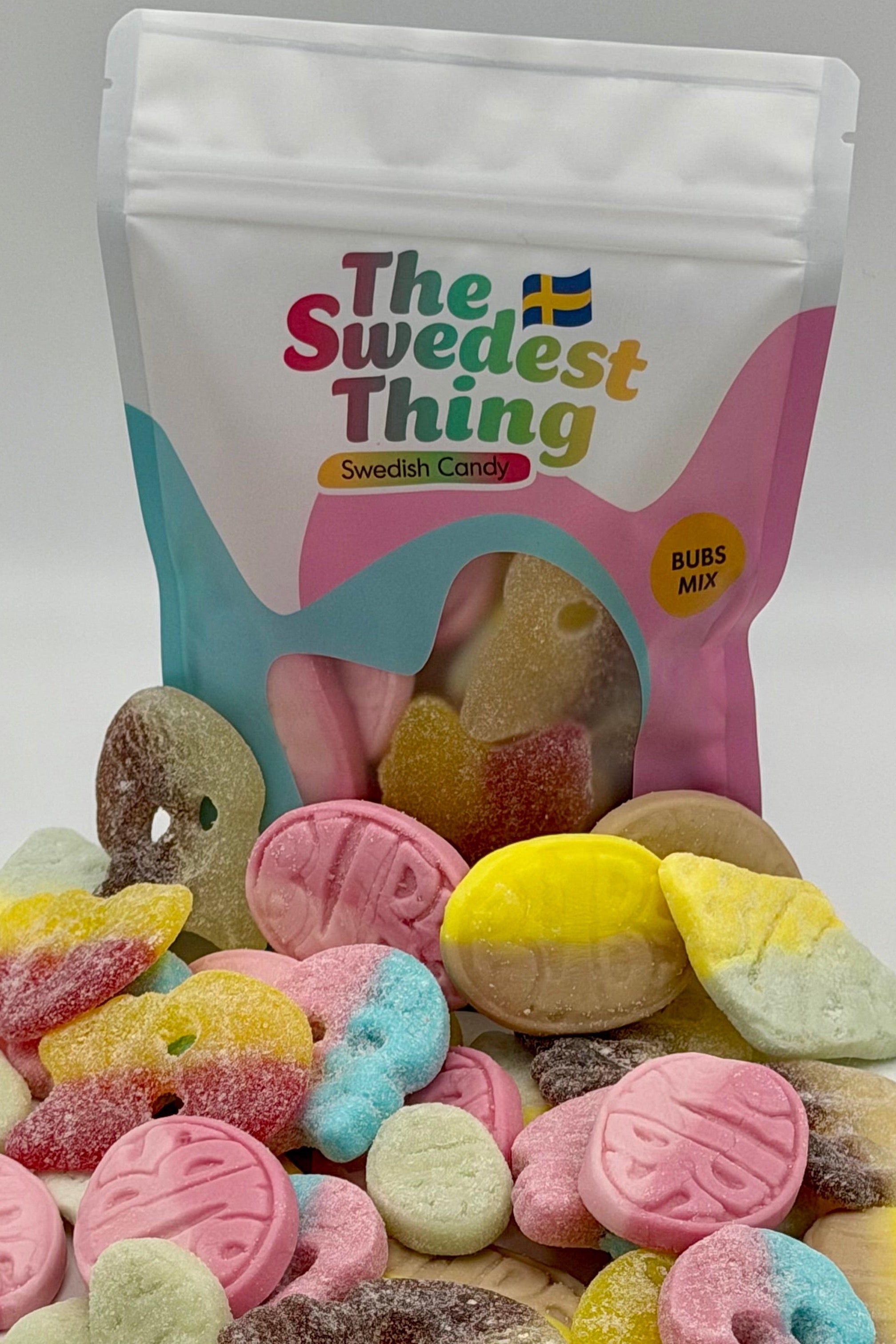 Colorful gummy candies in front of a 'The Swedest Thing' branded bag on a white background